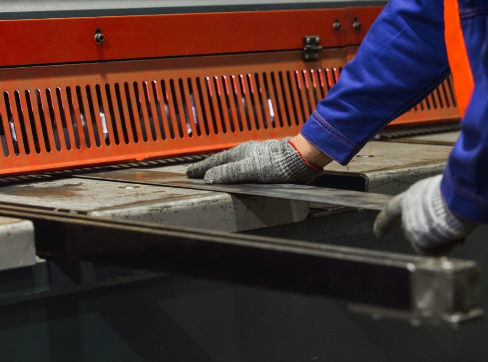 Manos cortando con cizalla CNC